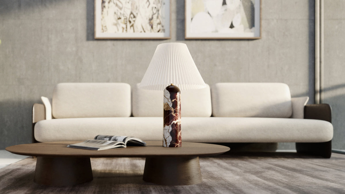 Table lamp with a burgundy marble base and a corrugated shade on a coffee table